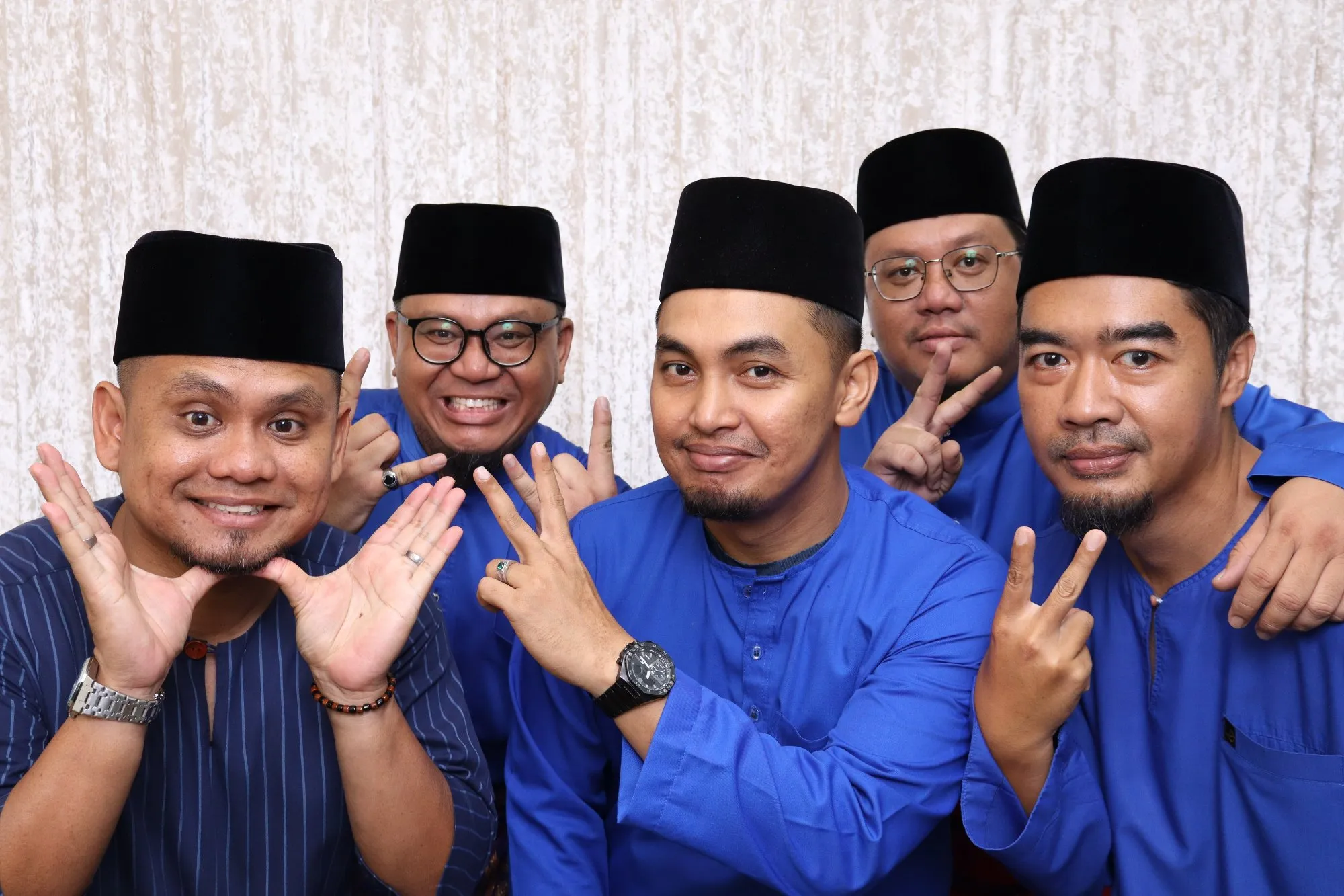 Aksi tetamu di depan backdrop photobooth pada rumah terbuka hari raya Majlis Rumah Terbuka Masz Formula Rich Empire & Permata Affim Empire di Dewan Bakawali