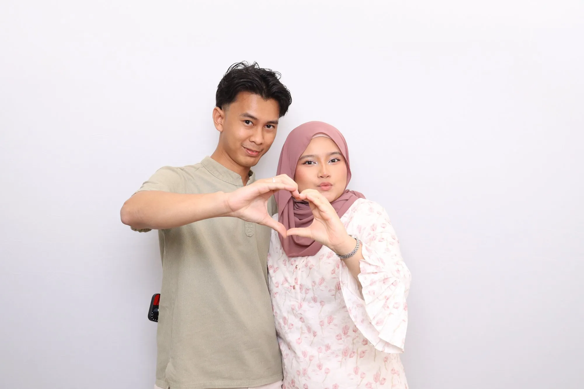 Aksi tetamu di depan backdrop photobooth pada majlis perkahwinan Hazirah & Lemad di Mana-mana Cafe