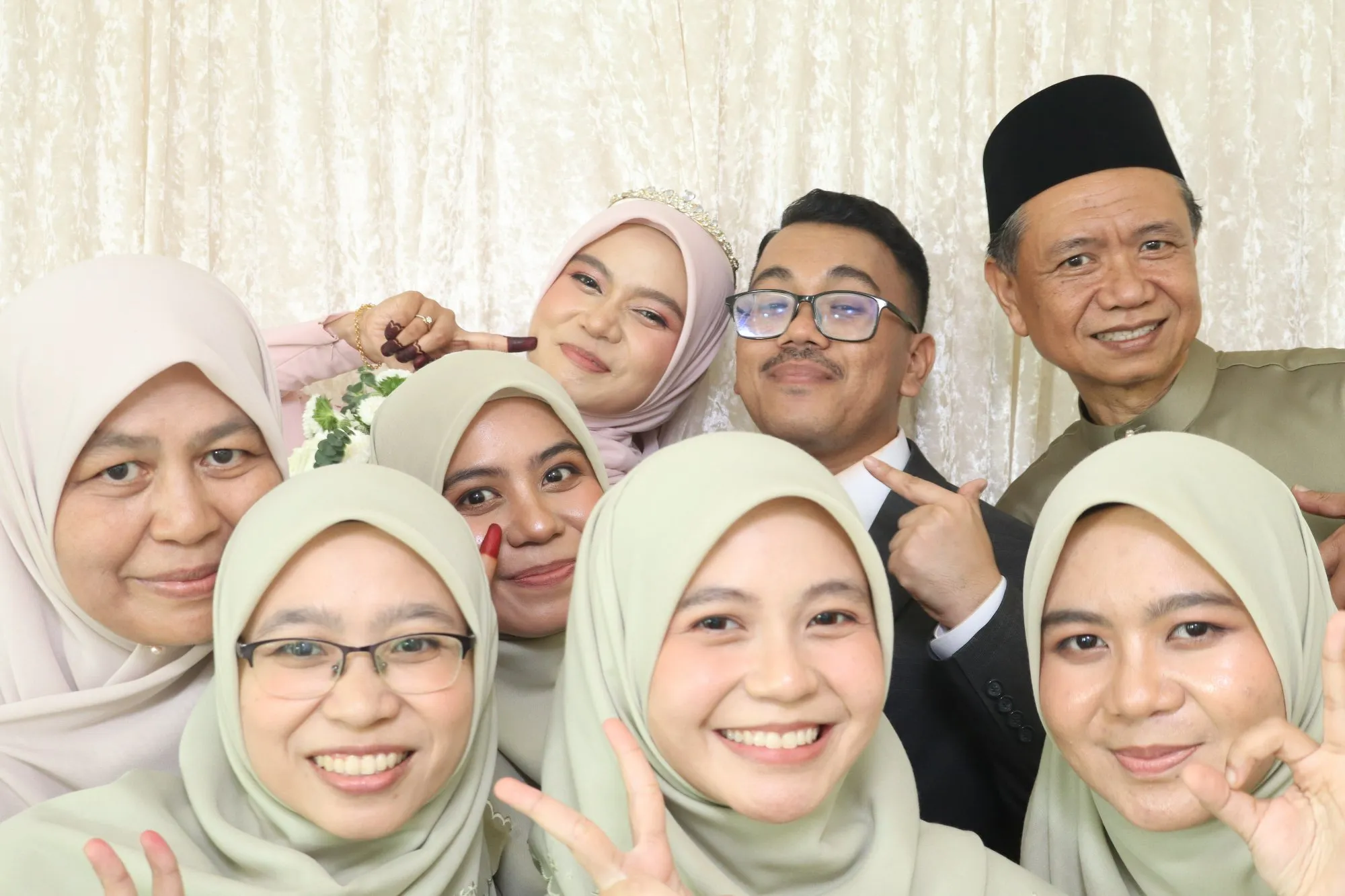 Aksi tetamu di depan backdrop photobooth pada majlis perkahwinan Balqis & Izzuddin di Dewan Atabara